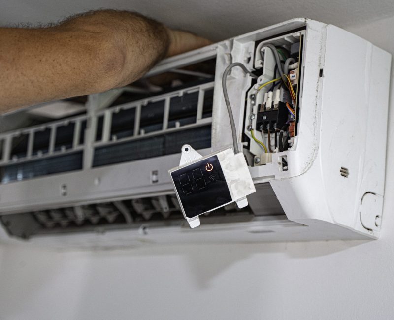 Technician repairing air conditioning unit during summer