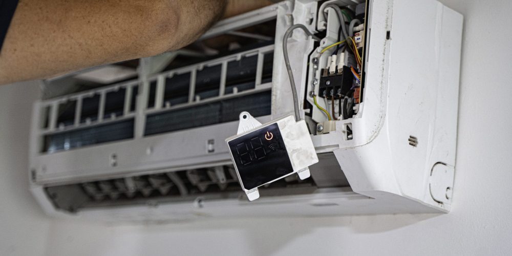 Technician repairing air conditioning unit during summer